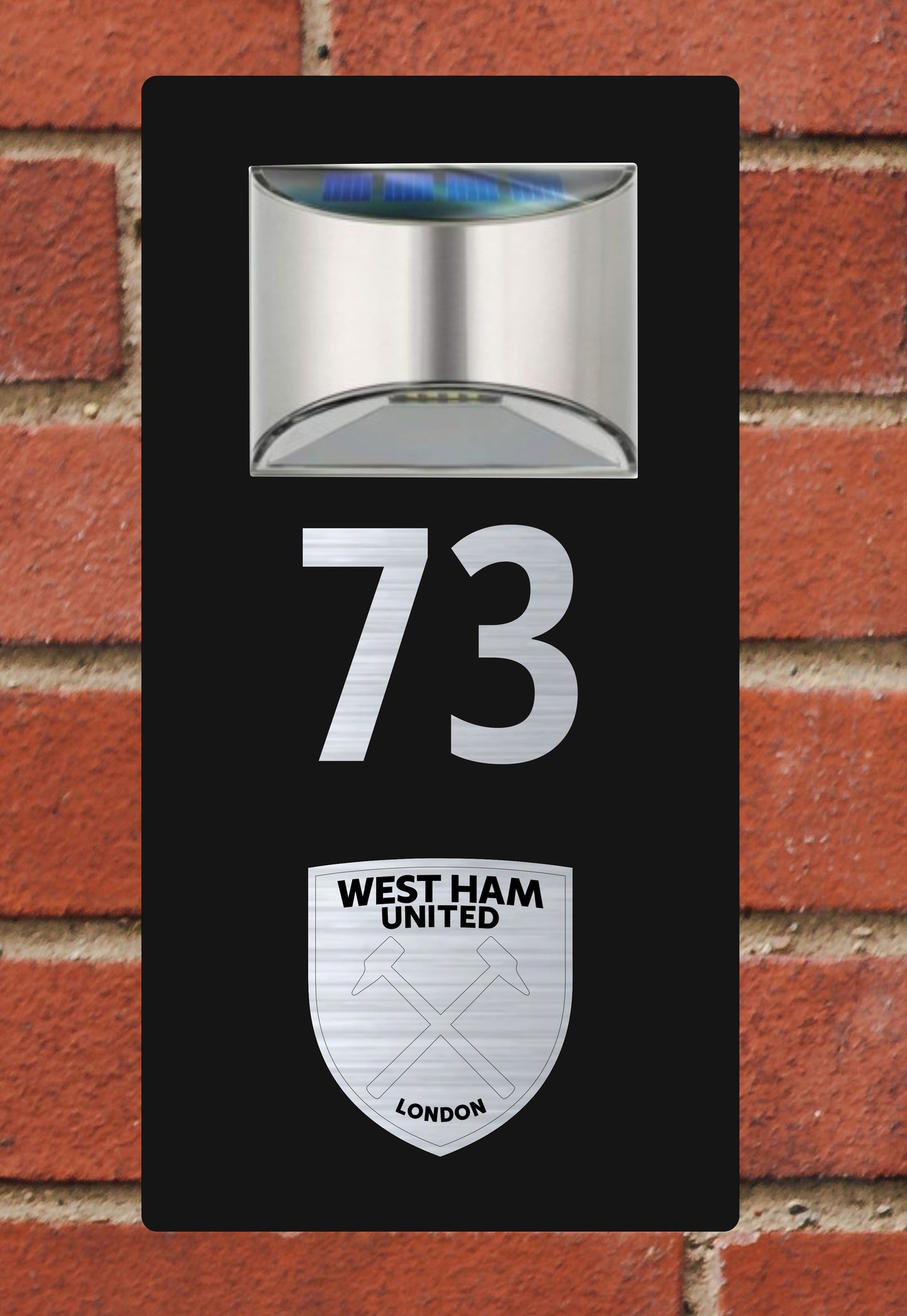 Solar light with West Ham United logo on a brick wall